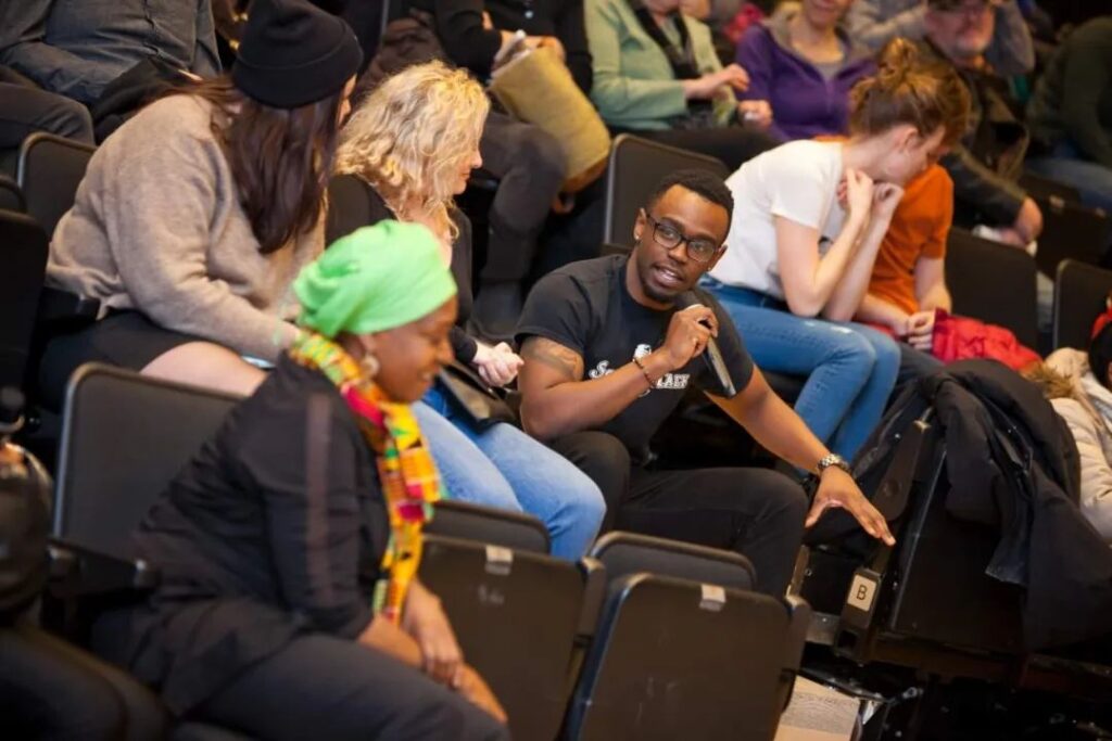 Kanaar with a mic in the audience at a talk